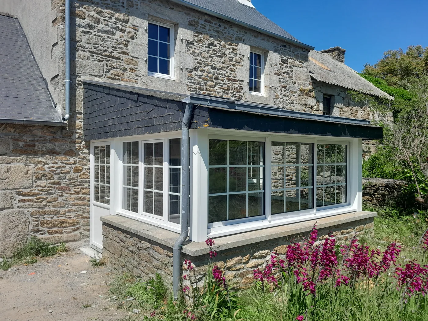 Véranda traditionnelle blanche sur maison en pierre près de Cléder — Coat-Amis Charpente menuisier